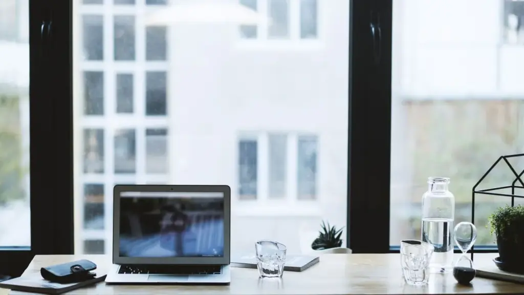 Offener Laptop auf einem Schreibtisch am Fenster