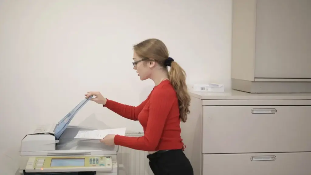 Multifunktionsdrucker druckt Fotos, eine Hand hält einen Stift